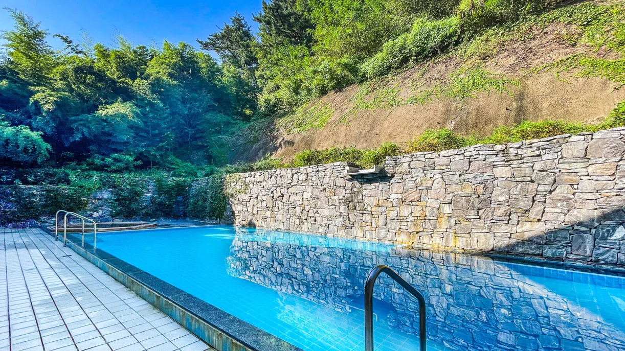 충남 예산 덕산온천지구에 위치한 세심천온천호텔 야외 온천 수영장, 돌담과 자연 숲이 어우러진 조용한 힐링 공간