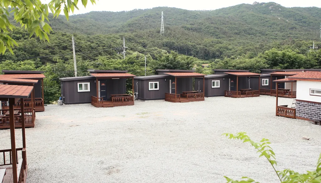 덕산참숯랜드의 편백하우스 외부 전경과 숲으로 이루어진 덕산 전경