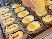 계란빵 틀에 반죽과 계란을 넣어 굽고 있는 모습, 한국의 인기 있는 길거리 간식