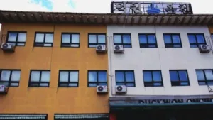 덕원온천 건물 외관 전경, 노란색과 흰색 외벽이 인상적인 온천 건물